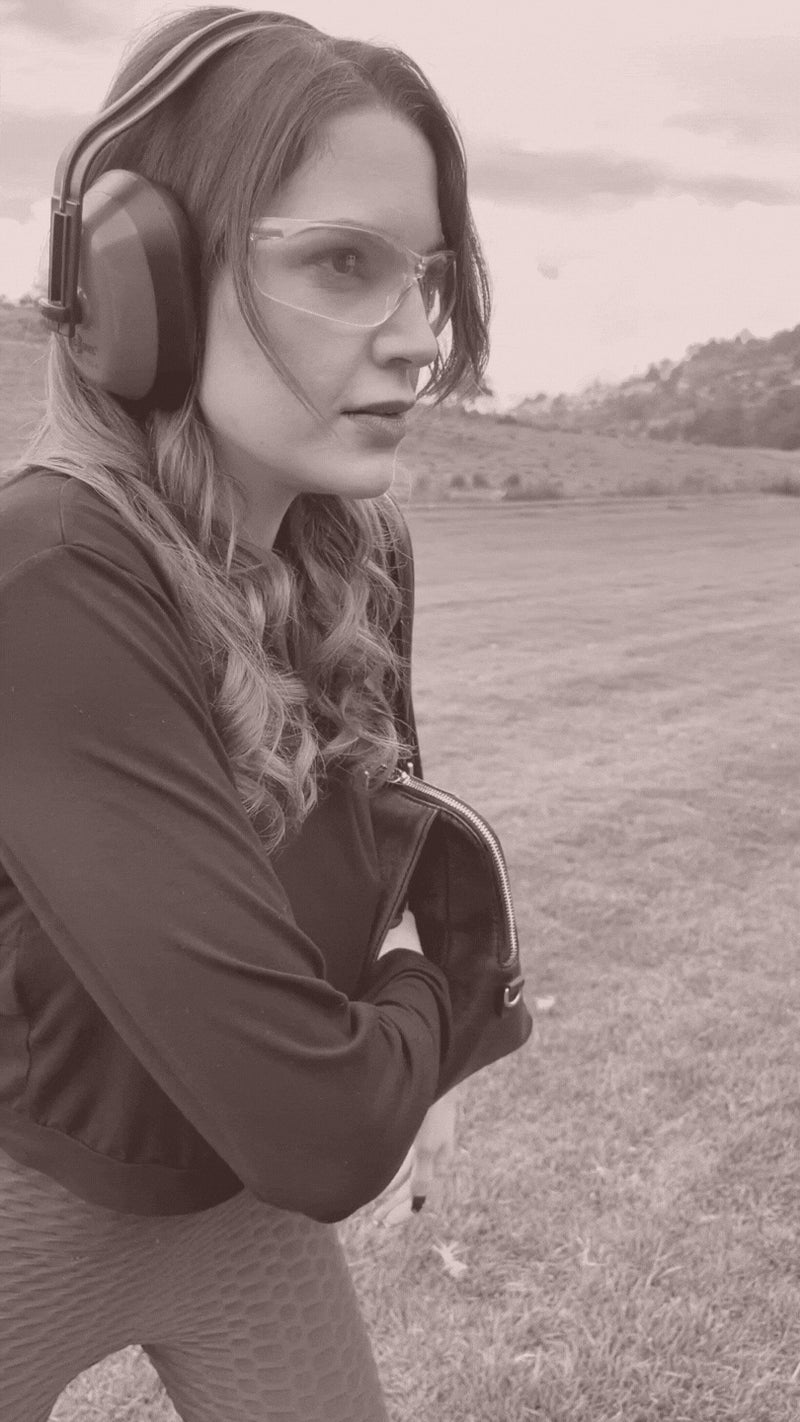Woman at the range practicing with her Zendira Tuesday Concealed Carry Satchel.