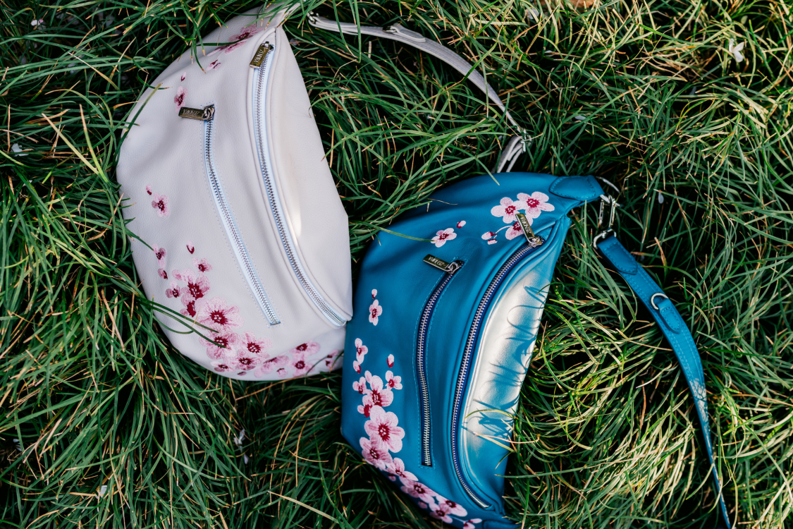 Embroidered cherry blossoms on the Zendira Saturday concealed carry bags on grass.
