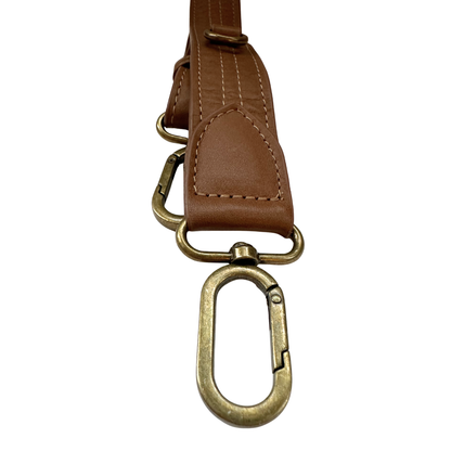 Hardware closeup photo of the Cafe Con Leche Zendira Saturday concealed carry crossbody bag with antique bronze hardware and smooth, soft neutral brown leather.